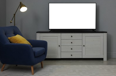 Image of Tv set with white screen on stand in room. Mockup for design