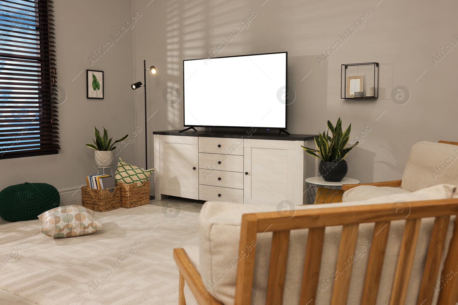 Image of Tv set with white screen on stand in room. Mockup for design