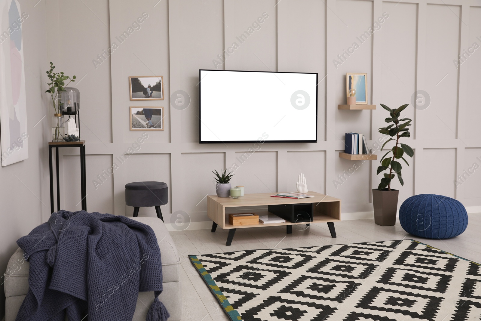 Image of Tv set with white screen mounted on wall in room. Mockup for design