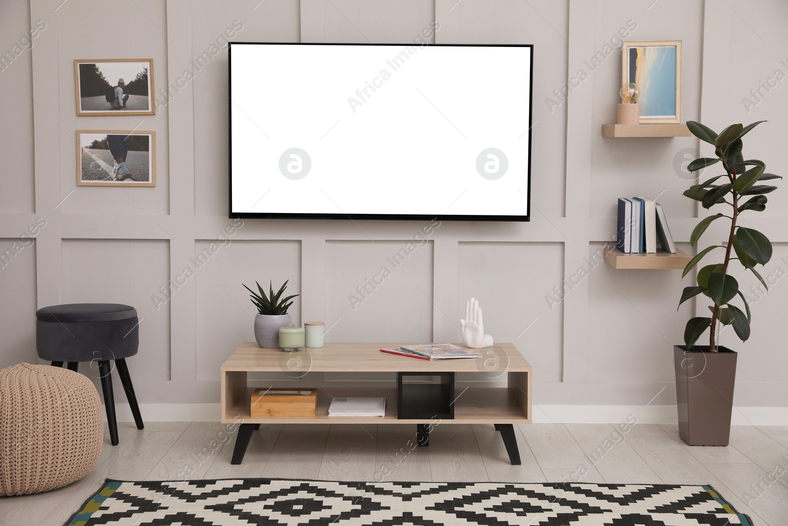 Image of Tv set with white screen mounted on wall in room. Mockup for design