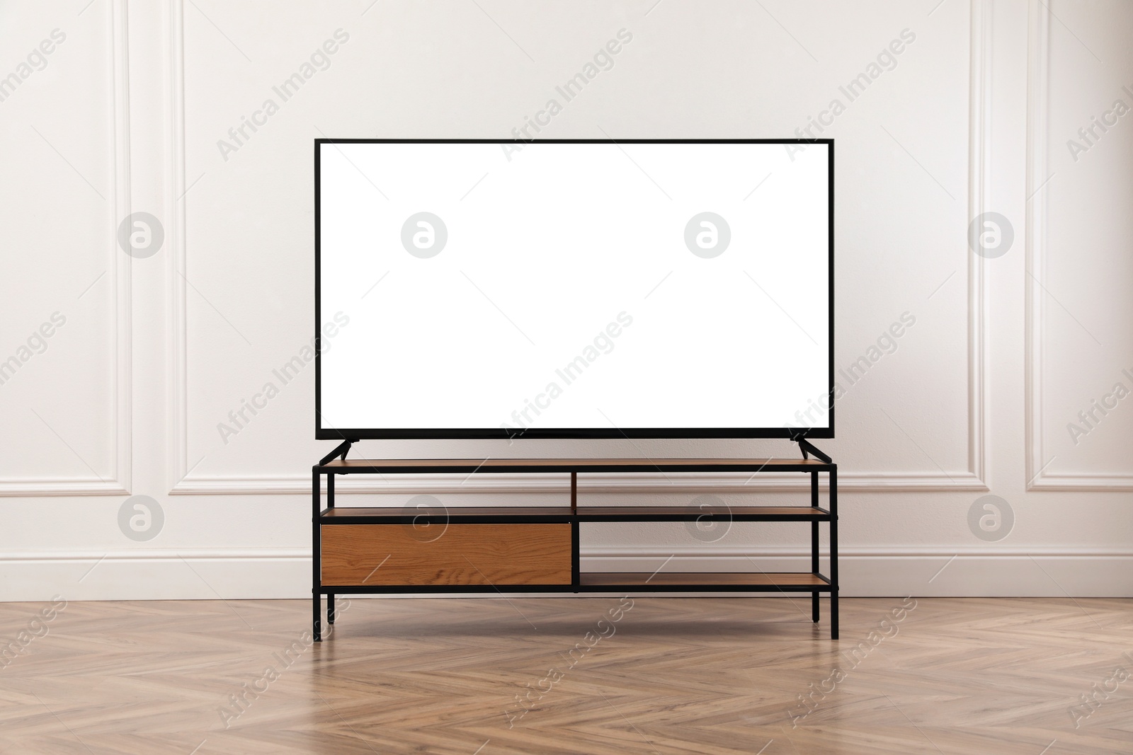 Image of Tv set with white screen on stand in room. Mockup for design