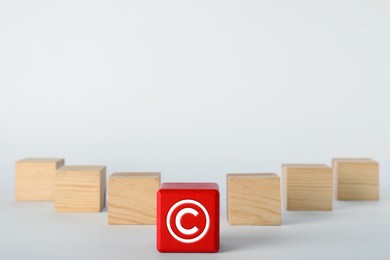 Image of License. One red cube with copyright symbol among others on white table