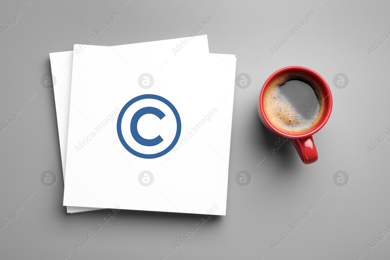 Image of License. Paper with copyright symbol and cup of coffee on grey table, top view