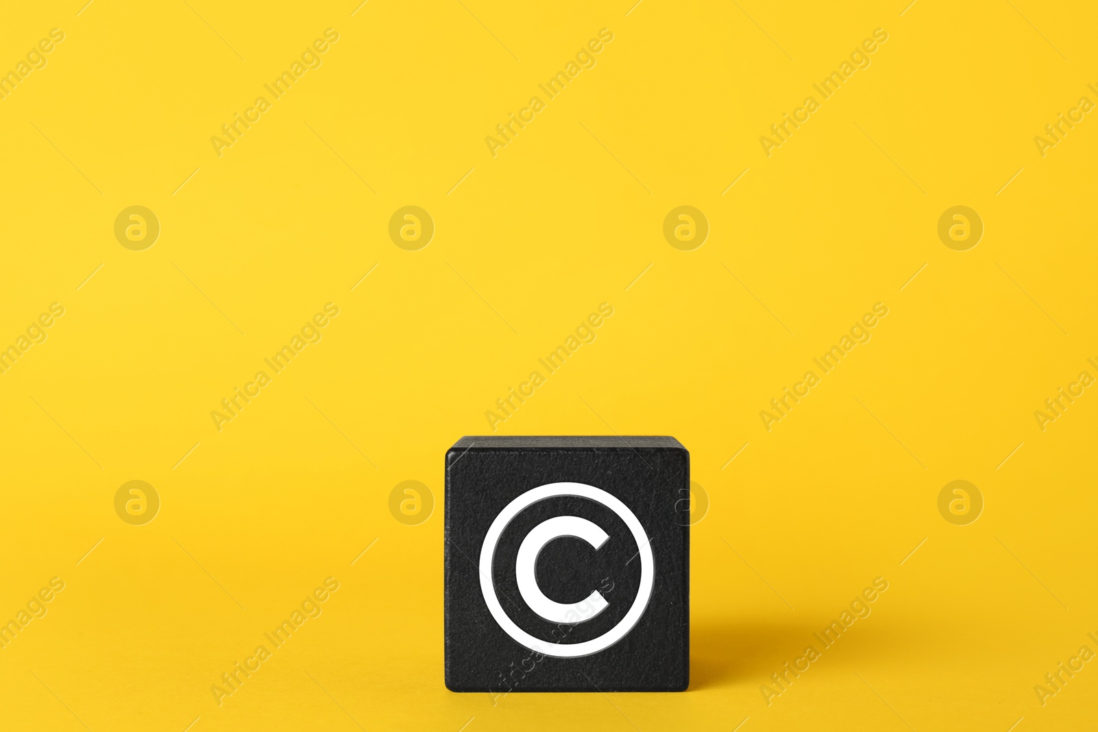 Image of License. One black cube with copyright on yellow background. Space for text