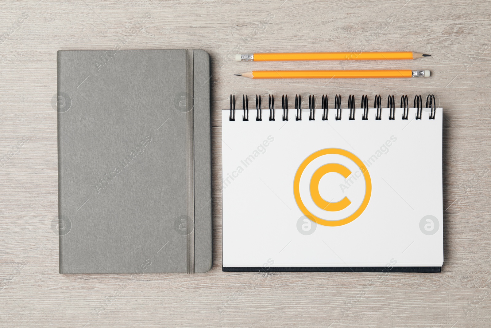 Image of License. Notebook with copyright symbol and pencils on wooden table, top view