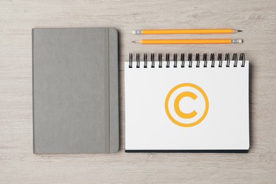 Image of License. Notebook with copyright symbol and pencils on wooden table, top view