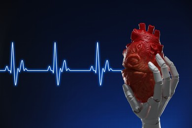 Image of Cardiology. Robot hand holding anatomical model of heart on gradient background. Blue heartbeat line