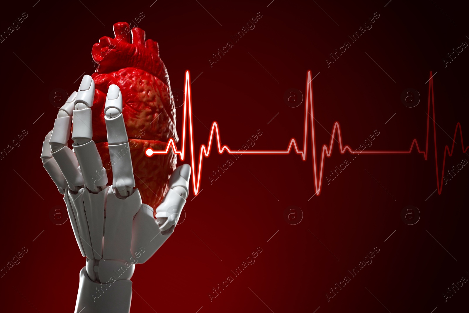 Image of Cardiology. Robot hand holding anatomical model of heart on gradient background. Red heartbeat line