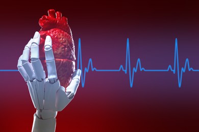 Image of Cardiology. Robot hand holding anatomical model of heart on gradient background. Blue heartbeat line