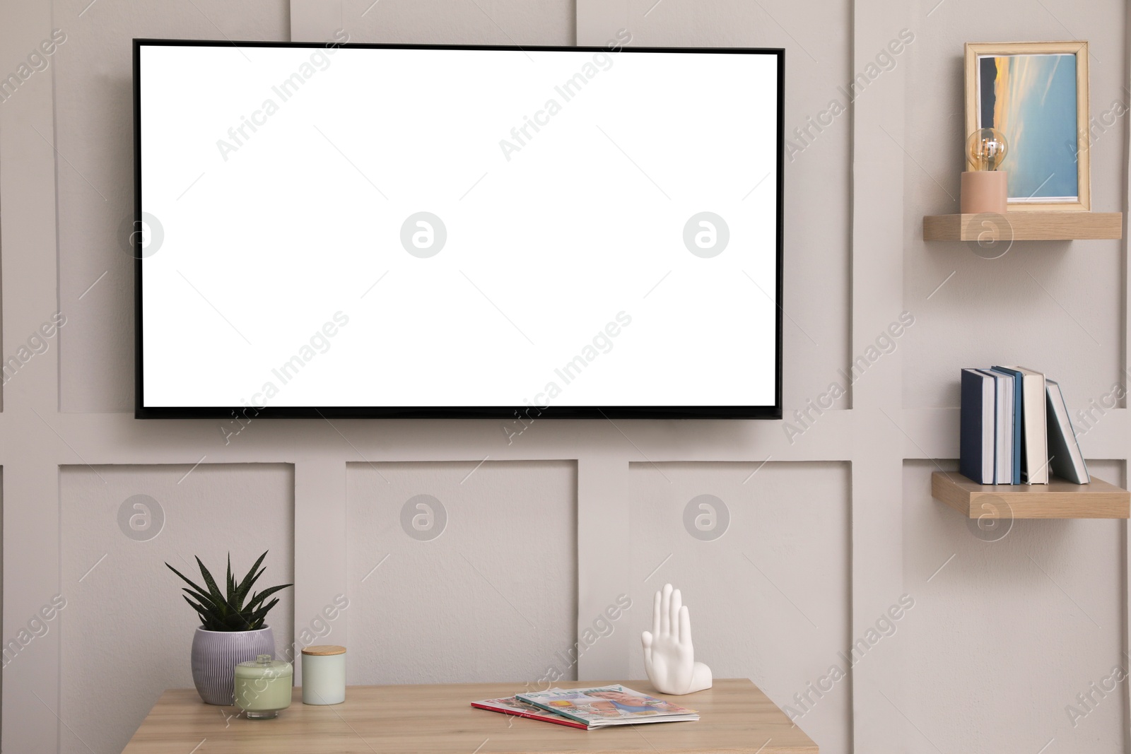 Image of Tv set with white screen mounted on wall in room. Mockup for design