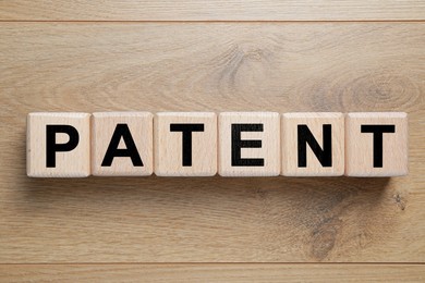 Image of License. Word Patent made of cubes with letters on wooden background, top view