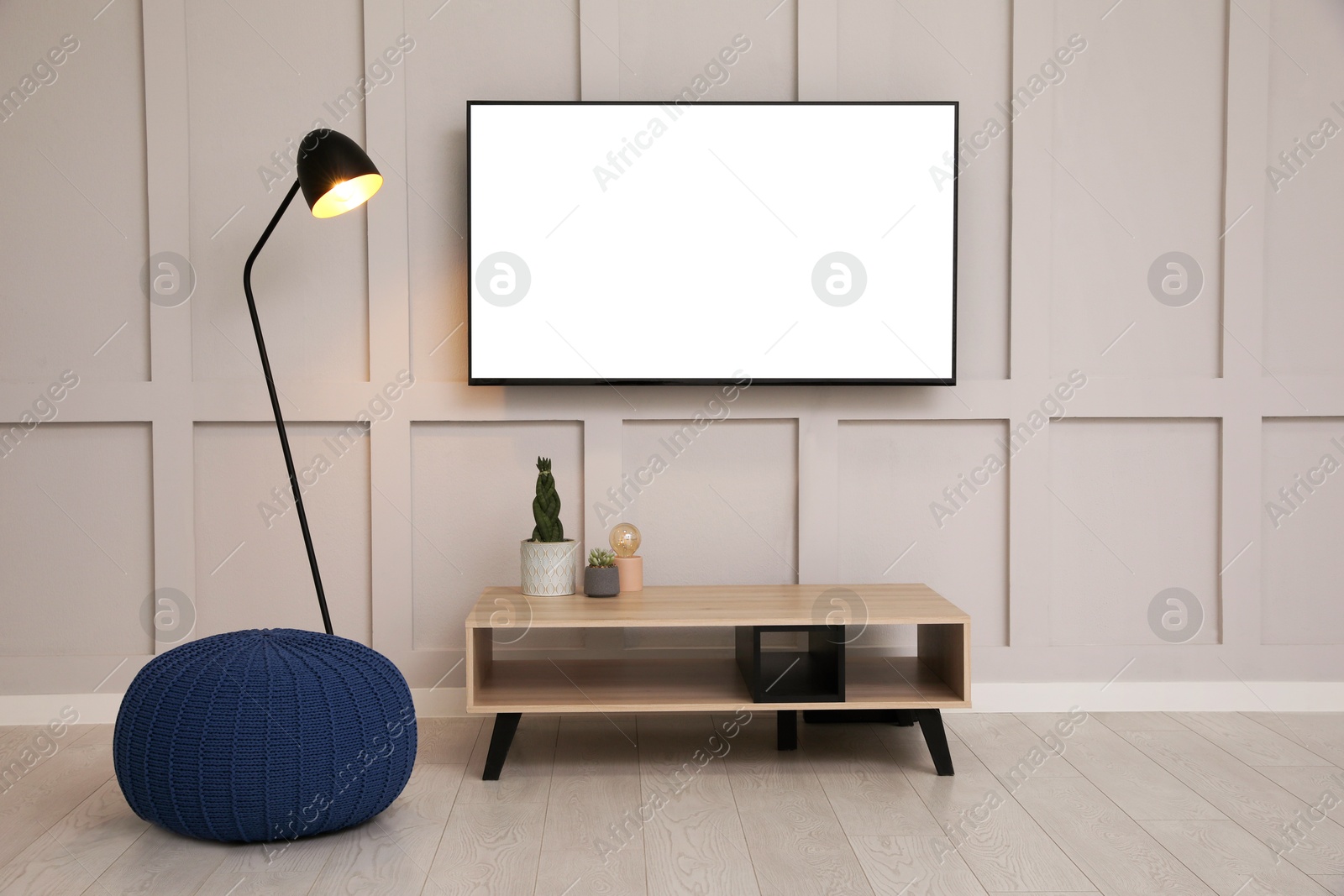 Image of Tv set with white screen mounted on wall in room. Mockup for design