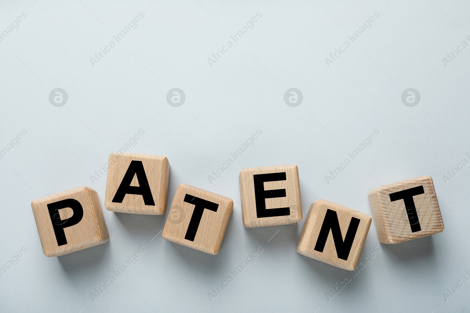 Image of License. Word Patent made of wooden cubes with letters on light grey background, top view