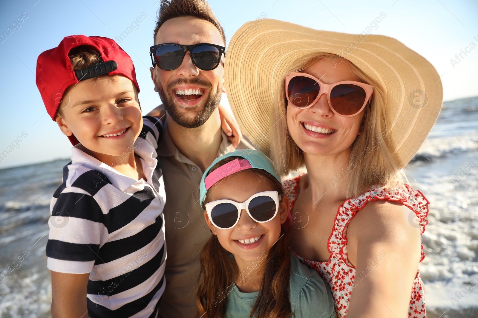 Photo of Happy family taking selfie on beach near sea. Summer vacation