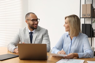 Photo of Coworkers with laptop working together in office