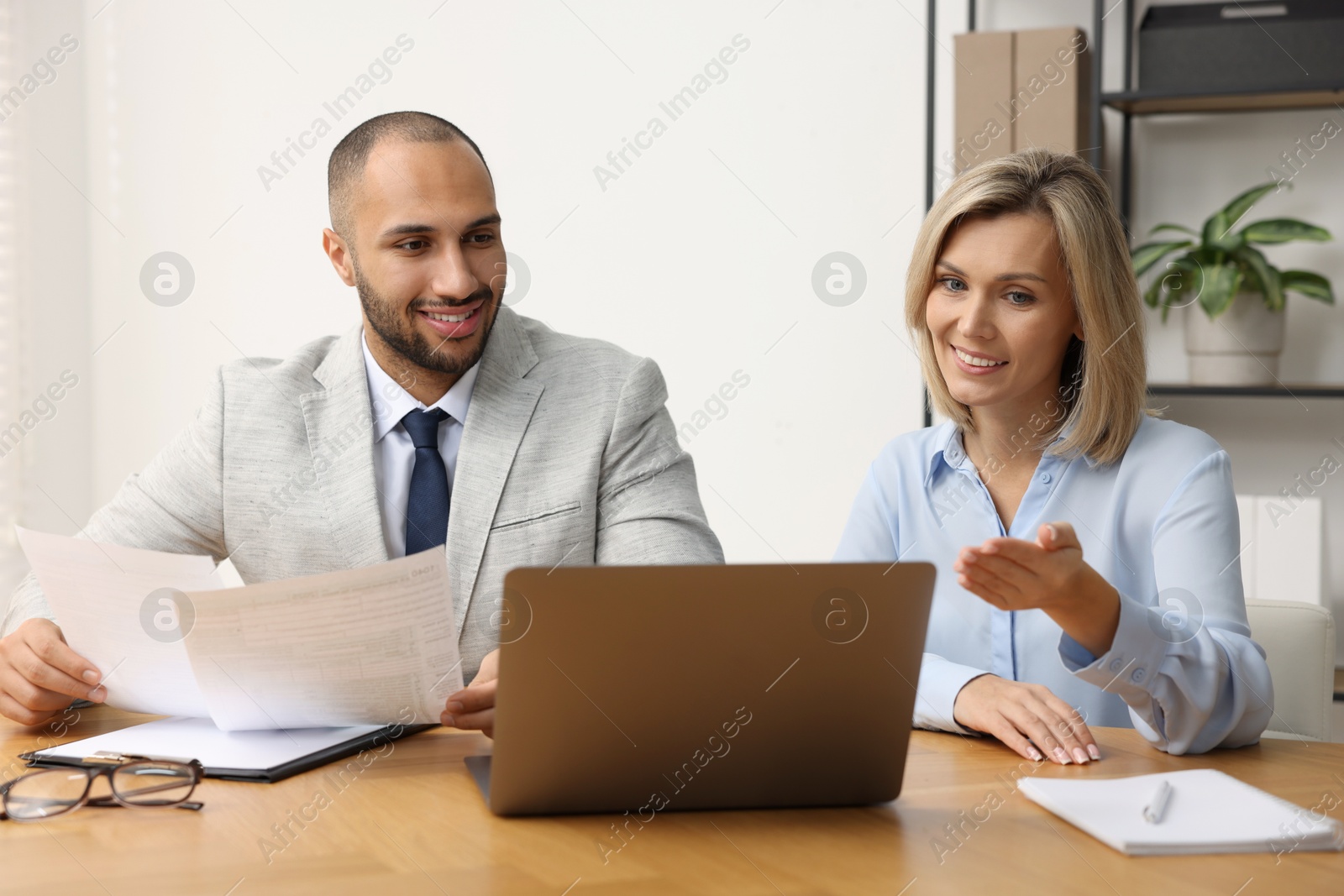 Photo of Coworkers with laptop working together in office