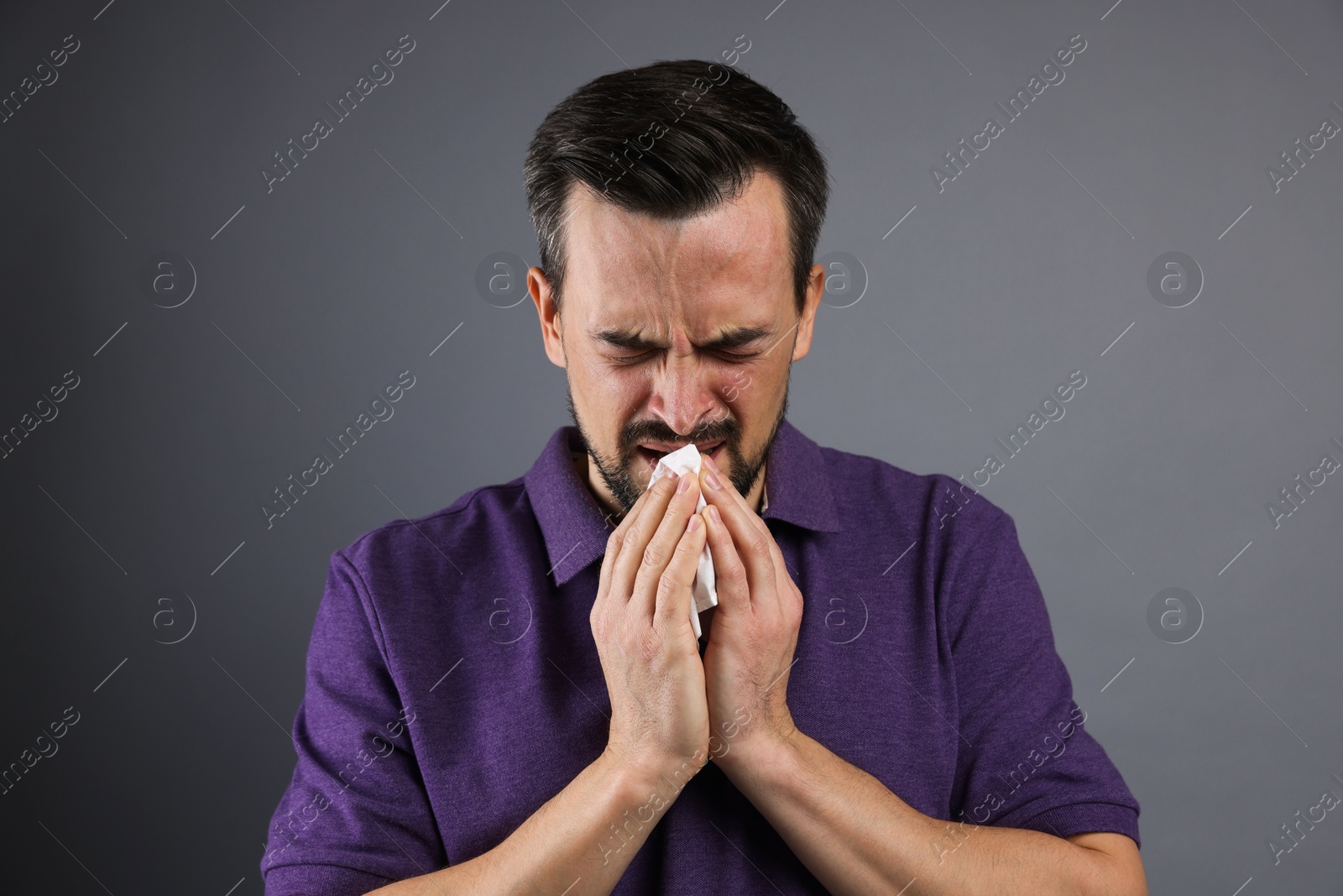 Photo of Sad man with paper tissue crying on grey background