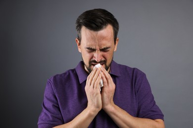 Photo of Sad man with paper tissue crying on grey background