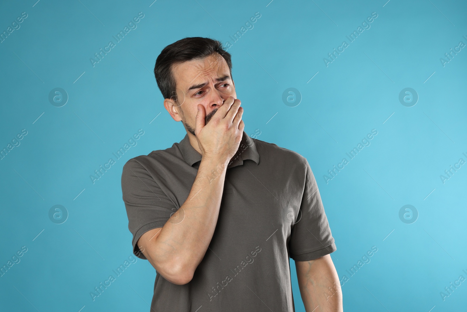 Photo of Sad man crying on light blue background