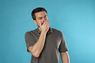 Photo of Sad man crying on light blue background