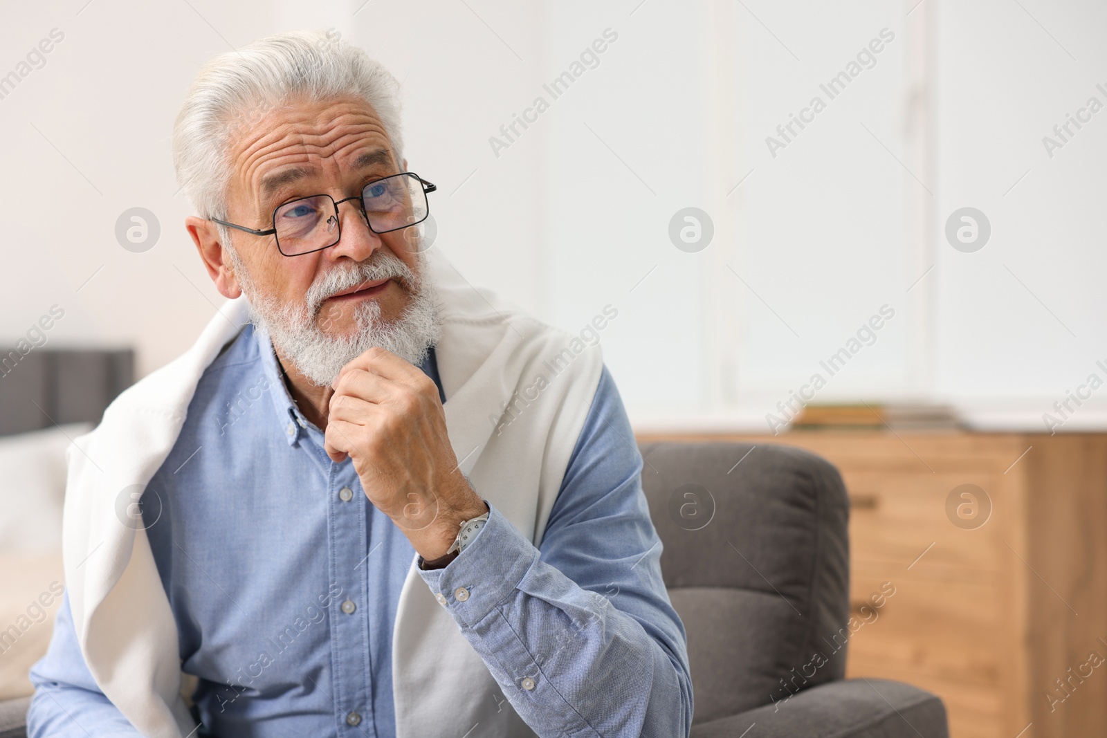 Photo of Handsome bearded man in armchair at home