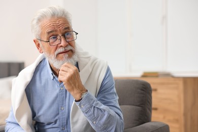 Photo of Handsome bearded man in armchair at home