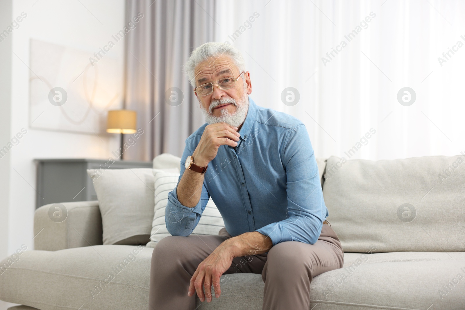 Photo of Portrait of handsome bearded man on sofa indoors