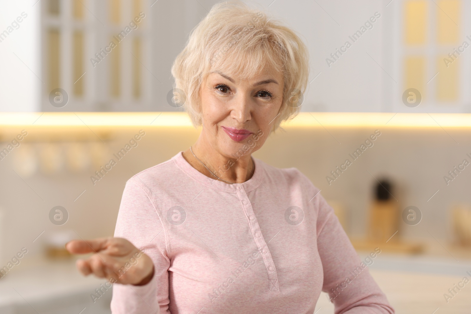 Photo of Portrait of grandmother with beautiful makeup in kitchen