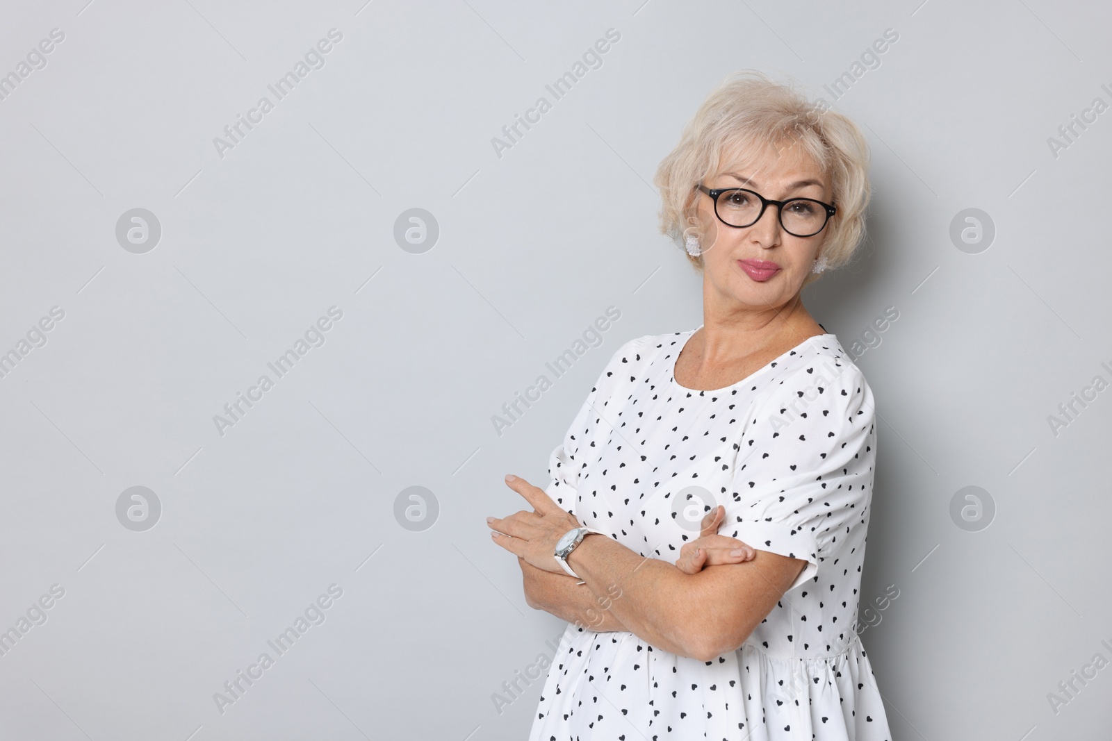 Photo of Portrait of elegant grandmother in glasses on light grey background. Space for text