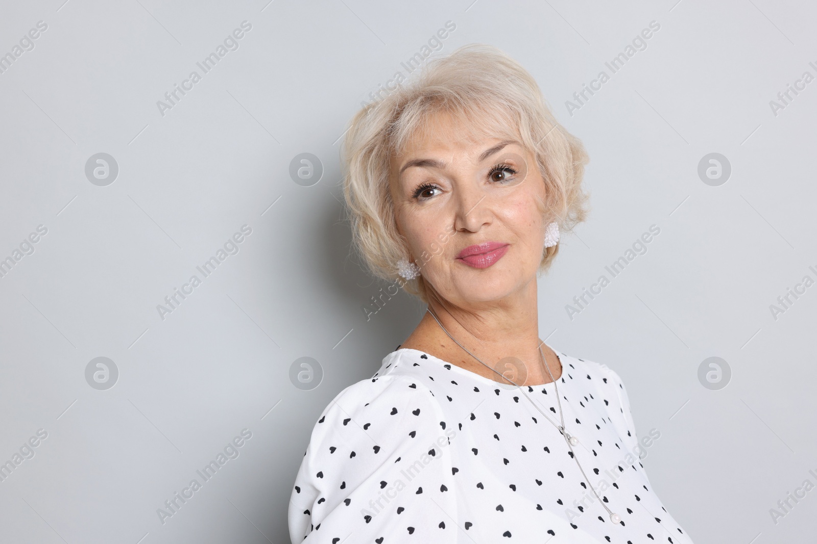 Photo of Portrait of grandmother on light grey background. Space for text