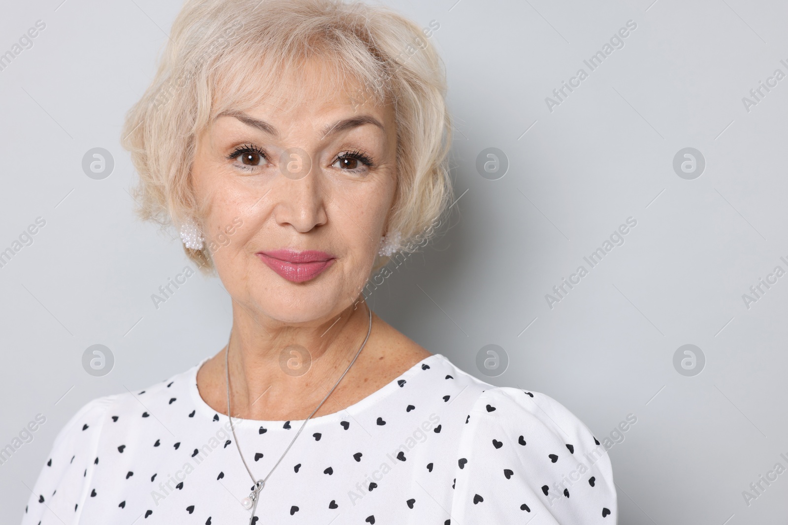 Photo of Portrait of grandmother on light grey background. Space for text