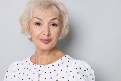 Portrait of grandmother on light grey background. Space for text