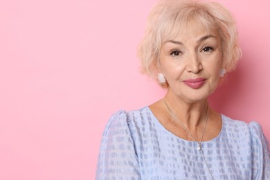 Photo of Portrait of elegant grandmother on pink background. Space for text