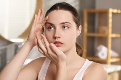 Photo of Young woman putting in green color contact lens indoors