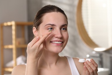 Photo of Young woman with green color contact lens indoors