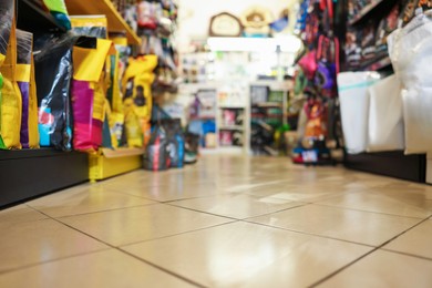 Photo of Shelves with different products in pet shop, selective focus