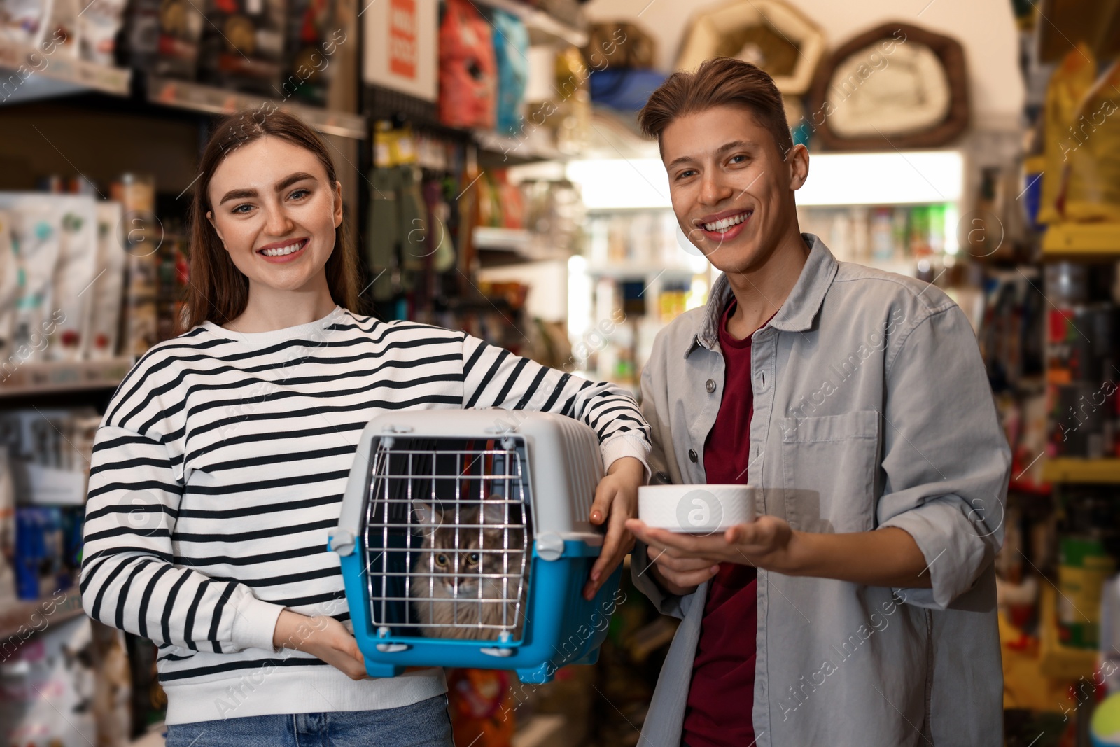 Photo of Couple choosing feeding bowl for their cat in pet shop