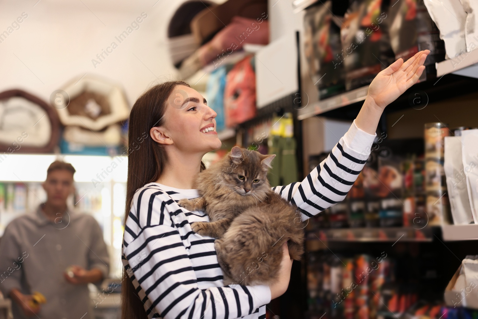 Photo of Woman with her cute cat in pet shop