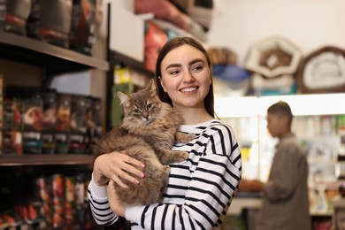 Woman with her cute cat in pet shop