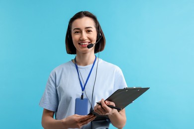 Photo of Technical support call center. Smiling operator with clipboard on light blue background