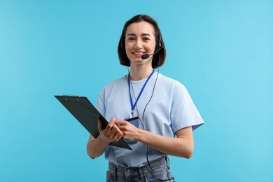 Photo of Technical support call center. Smiling operator with clipboard on light blue background