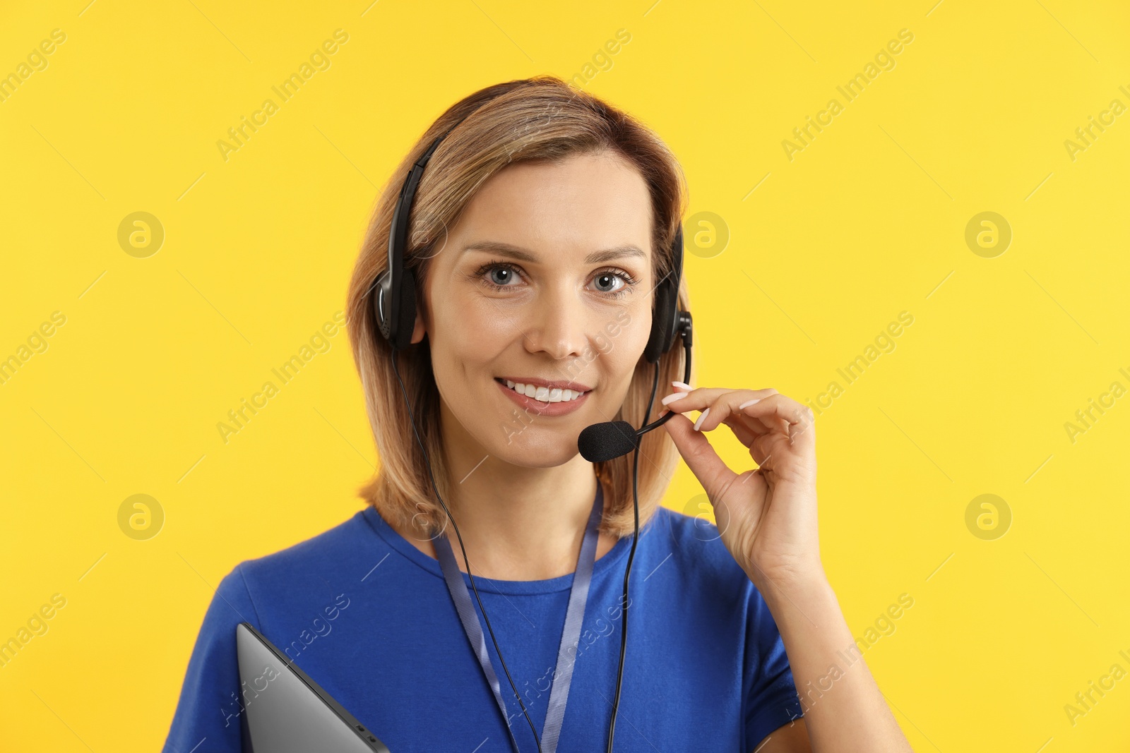 Photo of Technical support call center. Portrait of smiling operator on yellow background