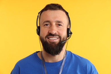 Photo of Technical support call center. Portrait of smiling operator on yellow background