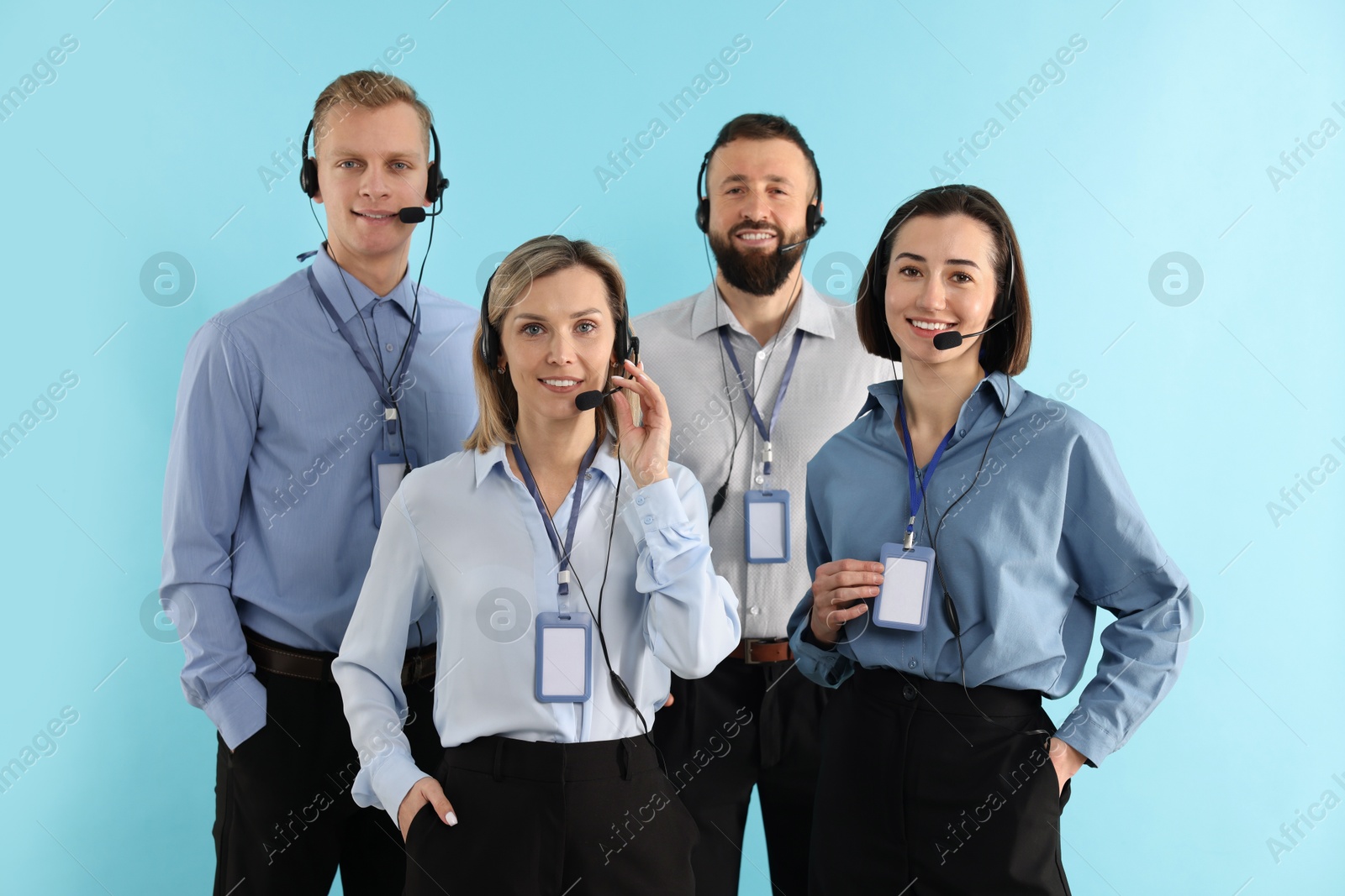 Photo of Technical support call center. Team of friendly operators on light blue background