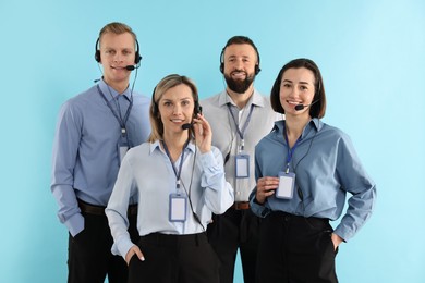 Photo of Technical support call center. Team of friendly operators on light blue background