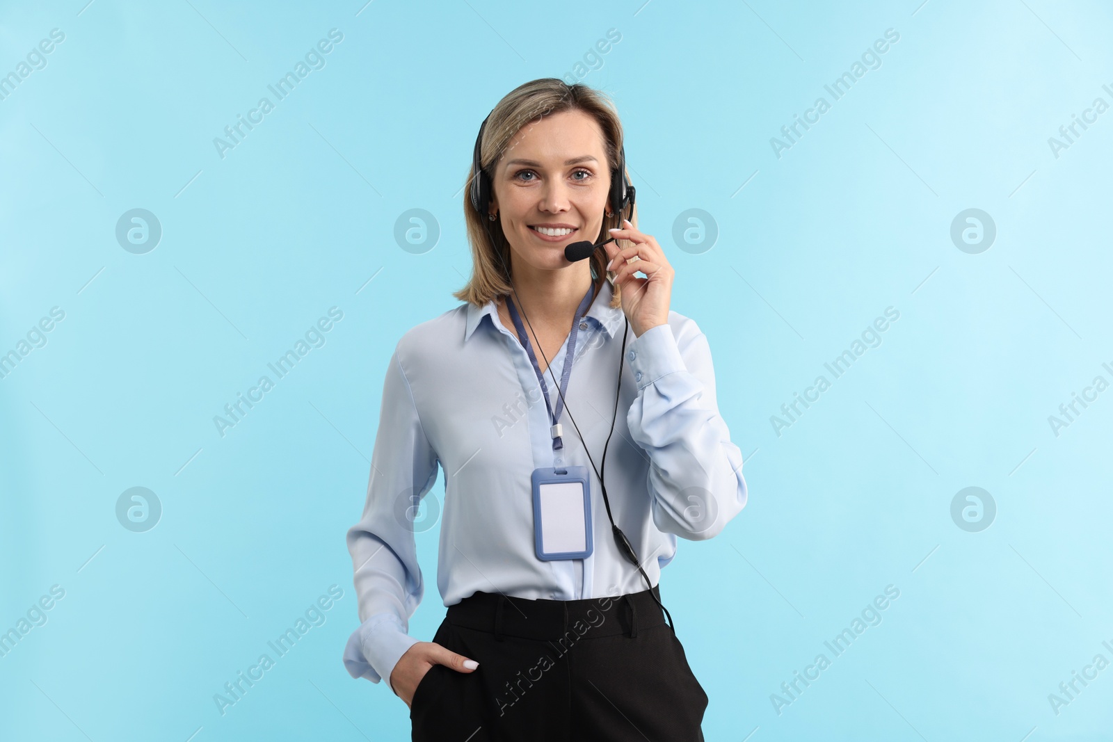 Photo of Technical support call center. Portrait of smiling operator on light blue background