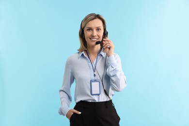 Photo of Technical support call center. Portrait of smiling operator on light blue background