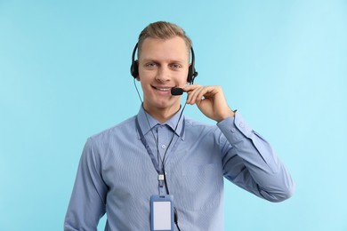 Photo of Technical support call center. Portrait of smiling operator on light blue background