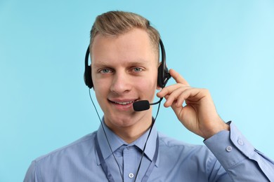 Photo of Technical support call center. Portrait of smiling operator on light blue background