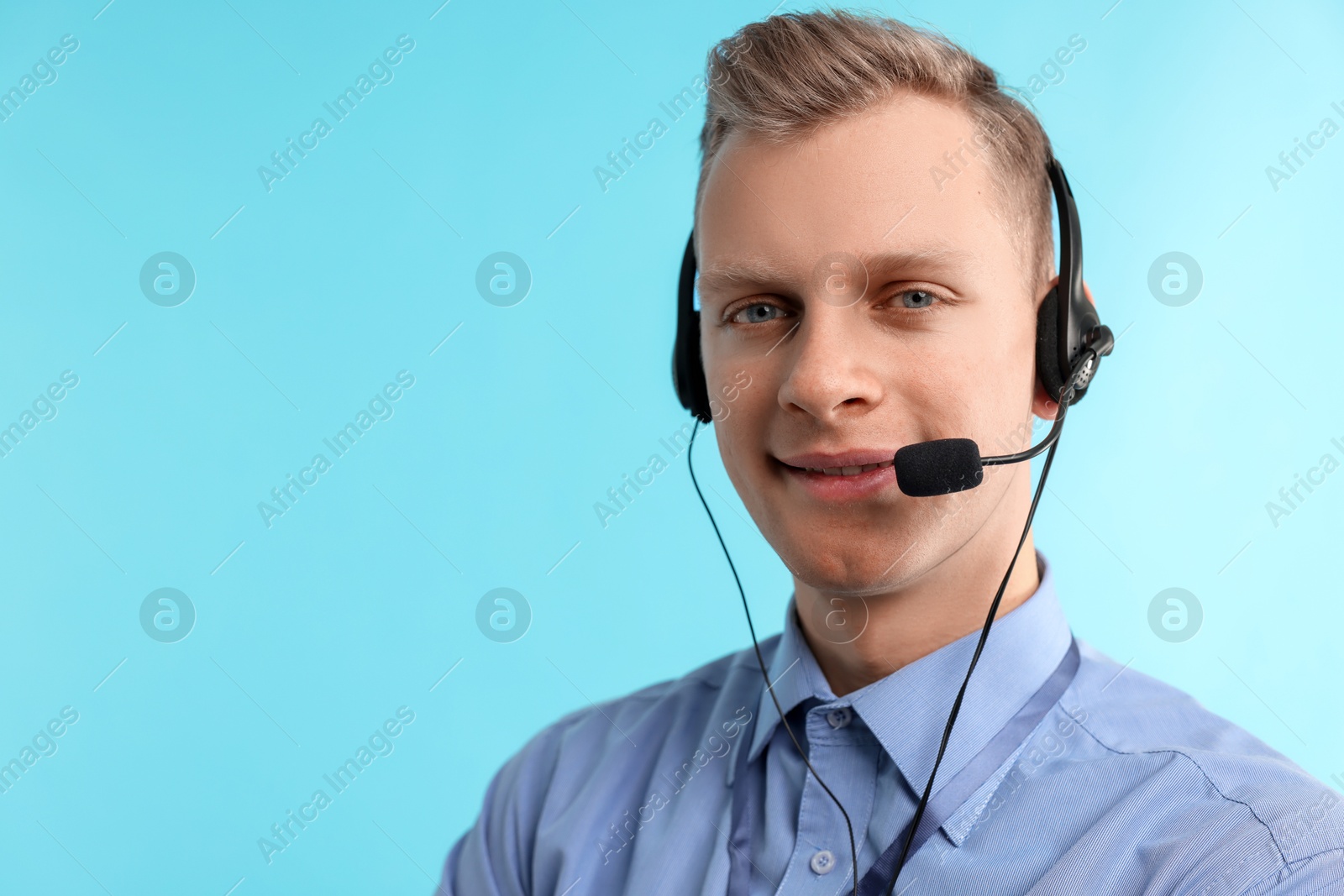 Photo of Technical support call center. Smiling operator on light blue background. Space for text